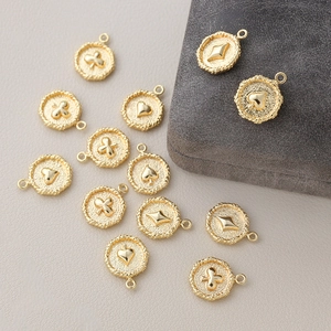 Vista detallada de dijes de cartas chapados en oro de 18k para joyería artesanal