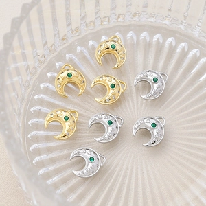 Dettaglio di ciondoli a mezzaluna in oro e argento con pietre verdi per gioielli DIY