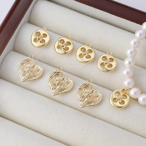 Vergulde hart- en knoopbedeltjes voor DIY-sieraden in een fluwelen sieradendoosje