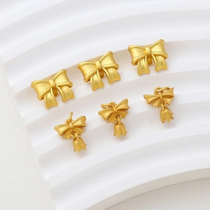 Detail of matte gold bow and lily of the valley charms for DIY jewelry making