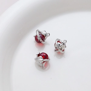 Macro shot of silver dolphin charms with red translucent beads for DIY jewelry making