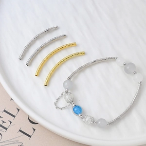 18K gold plated spiral tube beads for DIY jewelry making displayed on a white plate