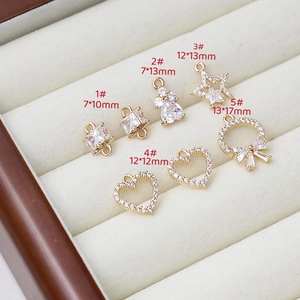 Detail of gold-plated star and heart charms with cubic zirconia for DIY jewelry