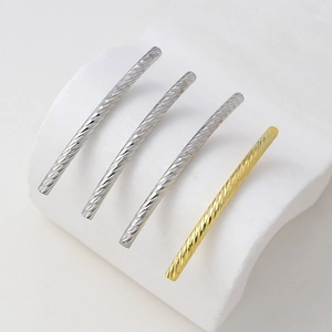 Close-up of spiral textured 18K plated copper jewelry tubes in silver and gold