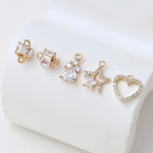 Detailed view of gold plated heart and star charms with zircon for DIY jewelry making