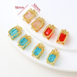 Detail von bunten Geschenkbox-Anhängern in Rosa, Blau und Rot mit goldenen Schleifen