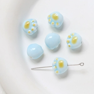 Détail de perles en céramique patte de chat bleu clair pour création de bijoux DIY