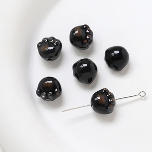 Gros plan d'une perle patte de chat en céramique noire brillante pour bijoux DIY