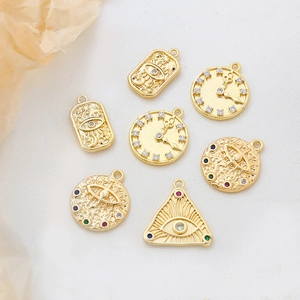 Detailansicht von 14k vergoldeten Himmelsanhängern mit Auge- und Sonnenmotiven für DIY-Schmuck