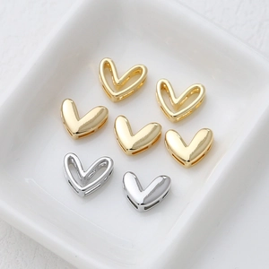 14k gold plated heart pendants and DIY jewelry components on a white ceramic tray