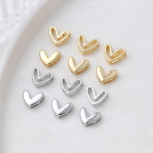Macro detail of hollow 14k gold-plated heart charms for DIY jewelry making and crafts