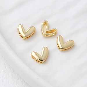 Close-up of polished heart-shaped 14k gold-plated jewelry charms for DIY accessories