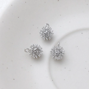 Macro view of three silver-plated starburst charms for DIY jewelry making accessories