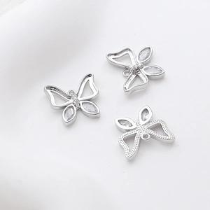 Macro shot of silver butterfly charms with butterfly-shaped cubic zirconia and hollow design