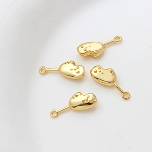 Close-up of 14k gold-plated DIY jewelry charms with star texture and smooth finish