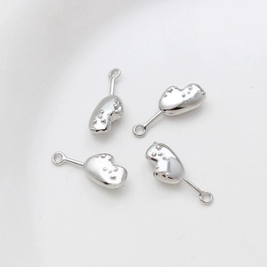 Detailed macro of four silver textured heart pendants for DIY jewelry crafting