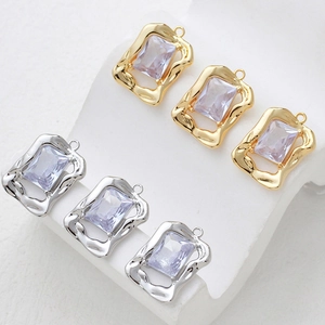 Macro detail of wave-edge heart pendants with rectangle purple zircons for jewelry DIY
