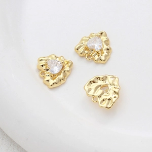 Detailed view of 14k gold plated heart pendants with zircon and irregular textures