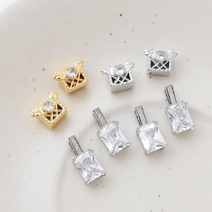 Macro view of 14k gold plated heart and rectangular zircon pendants on white ceramic