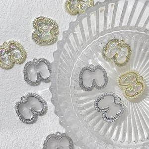 Détail de pendentifs nœud papillon avec strass et perles pour création de bijoux DIY
