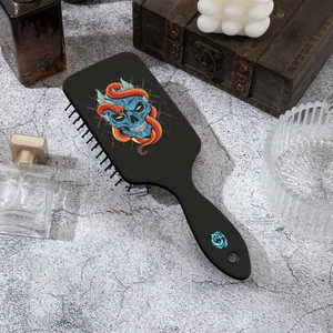 Detail view of gothic skull and snake print on black cushion hairbrush with massage bristles