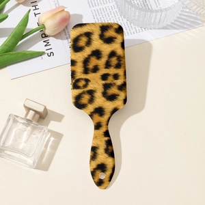 Dettaglio spazzola per capelli leopardata con foro per appenderla su sfondo sobrio