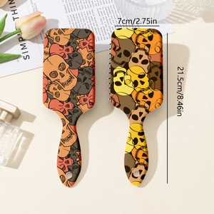 Set of two vintage skull pattern hairbrushes with dimensions 21.5cm by 7cm