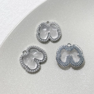 Détails de pendentifs nœuds argentés avec perles et incrustations pour bijoux artisanaux