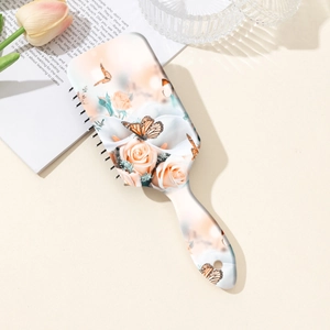 Brosse de massage pneumatique à motifs fleurs et papillons pour cuir chevelu sur blanc