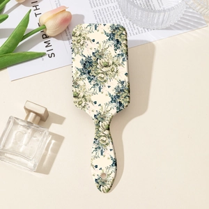 Detail of floral massage hairbrush on elegant tabletop with tulips and perfume