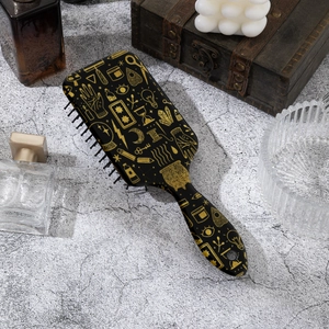 Retro black and gold patterned air cushion hairbrush for scalp massage on stone surface