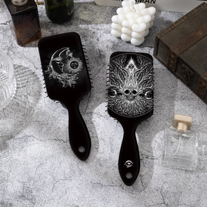 Gothic skull and celestial print square air cushion hairbrush set on stone surface