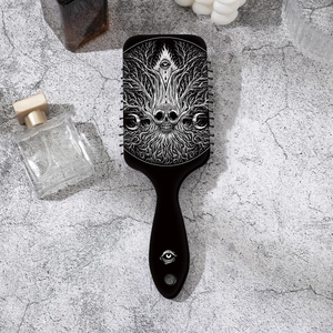 Macro detail of gothic skull and moon print on black air cushion paddle hairbrush