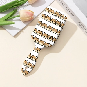 Détail de l'imprimé Shiba Inu sur le dos d'une brosse à cheveux carrée blanche sur bureau