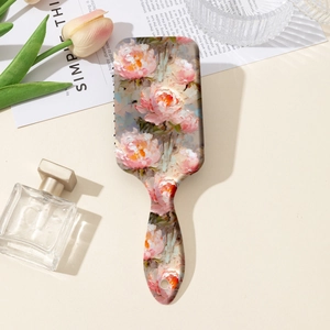 Close-up of pink peony floral painting on a rectangular cushion massage hairbrush