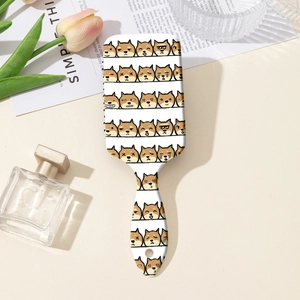 Détail d'une brosse à cheveux à coussin d'air blanc avec motifs Shiba Inu mignons