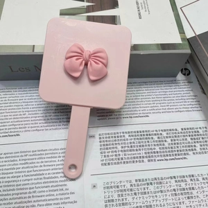 Pink handheld makeup mirror with bow decoration and portable comb set for girls