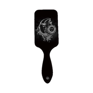 Black rectangular paddle hairbrush with mystical sun moon and star pattern over white background