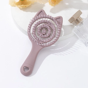 Detail of macaron pink cat-ear hairbrush with spiral hollow back and heart-shaped hole