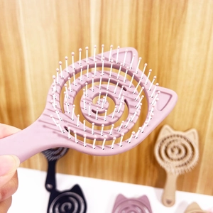 Detail view of pink cat-shaped spiral hollow hairbrush with massaging bristles