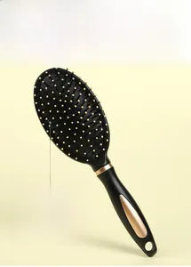 Detail of black air cushion massage brush with champagne gold trim and hanging hole