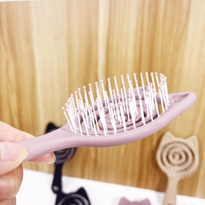 Detail of macaron purple cat ear hairbrush with hollow spiral design and white massage pins