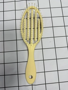 Détails d'une brosse squelette incurvée avec picots de massage et poignée antidérapante