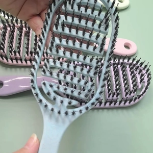 Detail of detangling hair brush with curved hollow back and dual bristle design