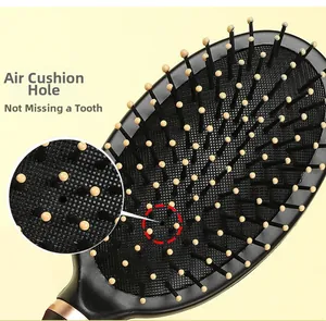 Detail of the air cushion hole on a black massage hairbrush with golden accent