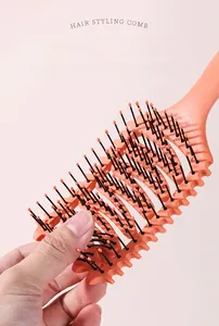 Close-up of flexible nylon bristles with orange ball tips on a hollow styling hairbrush