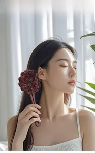 Deep red floral-shaped hairbrush shown detailing hair detangling and scalp massage