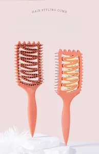 Macro view of coral orange S-shaped hollow backplane design on a styling hairbrush