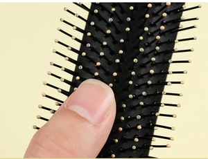 Detail of flexible black air cushion and smooth massage bristles on hair brush