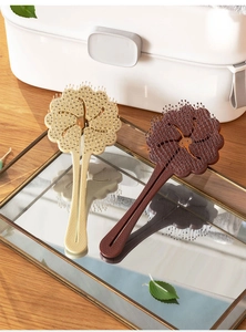 Detail of flower-shaped hair brushes with massage bristles on a mirrored tray